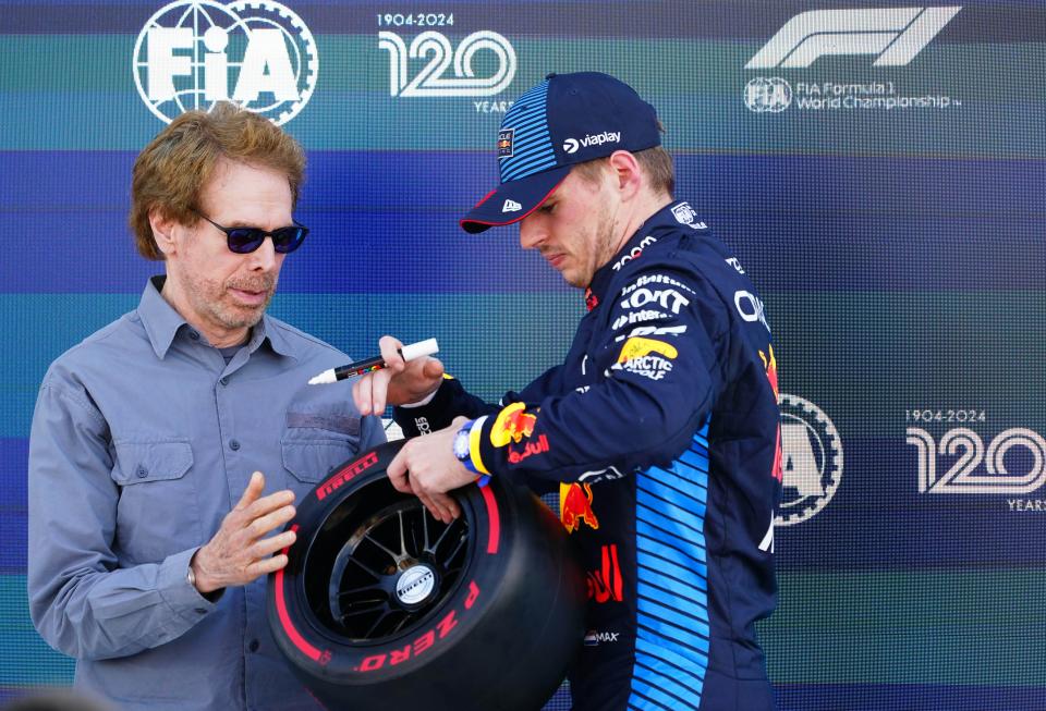 May 4, 2024; Miami Gardens, Florida, USA; American film and television producer Jerry Bruckheimer signs the Pole Position Trophy with Red Bull Racing driver Max Verstappen (1) after qualifying P1 for the Miami Grand Prix at Miami International Autodrome. Mandatory Credit: John David Mercer-USA TODAY Sports