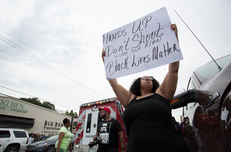 Community members demonstrate after a vigil in memory of Alton Sterling.