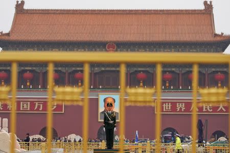 A paramilitary policeman stands guard before a giant portrait of late Chinese Chairman Mao Zedong at the Tiananmen gate, a day before the congress begins. REUTERS/Aly Song