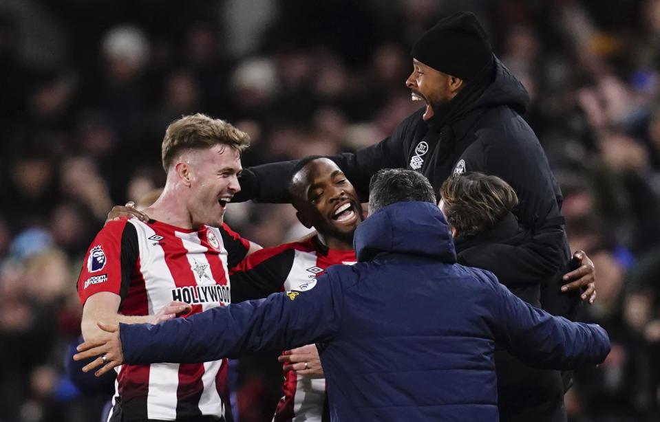 Brentford's Ivan Toney, centre, celebrates with teammates Nathan Collins and staff after scoring his side's first goal of the game, during the English Premier League soccer match between Brentford and Nottingham Forest, at the Gtech Community Stadium, in London, Saturday, Jan. 20, 2024. (John Walton/PA via AP)