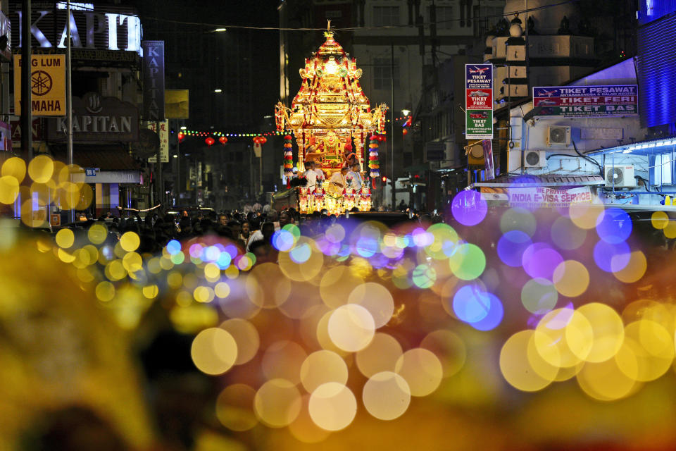 The gold chariot bearing the idol of Hindu god Lord Murugan leaves a temple to mark the start of Thaipusam, an annual festival representing the struggle between good and evil, on Penang Island, Wednesday, Jan. 24, 2024. Thousands of people attended the annual procession celebrated by devotees in honor of the Hindu god to express their gratitude, fulfill vows, and perform penance. (AP Photo/Vincent Thian)