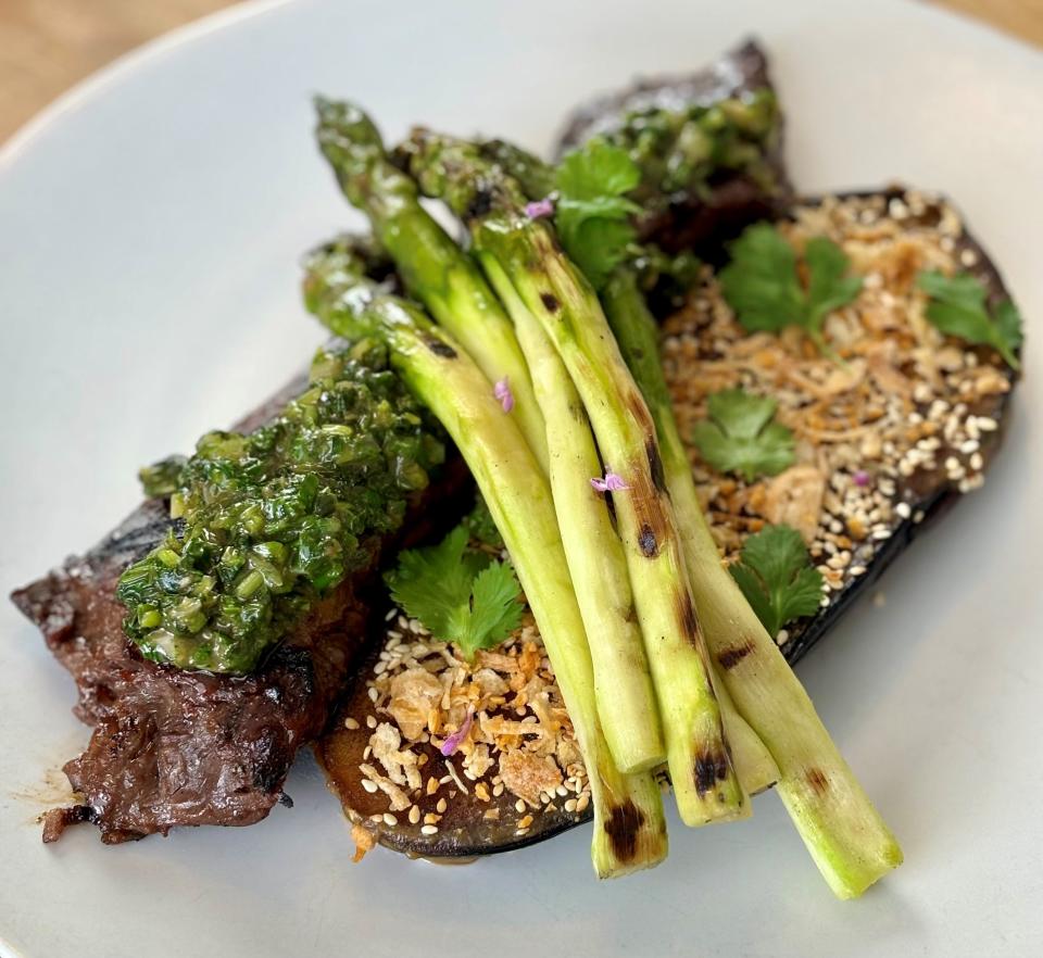 Grilled hanger steak with miso-glazed eggplant sourced from Two Barn Farm, topped with scallions and sesame seeds and alongside grilled asparagus at Juniper Hill.