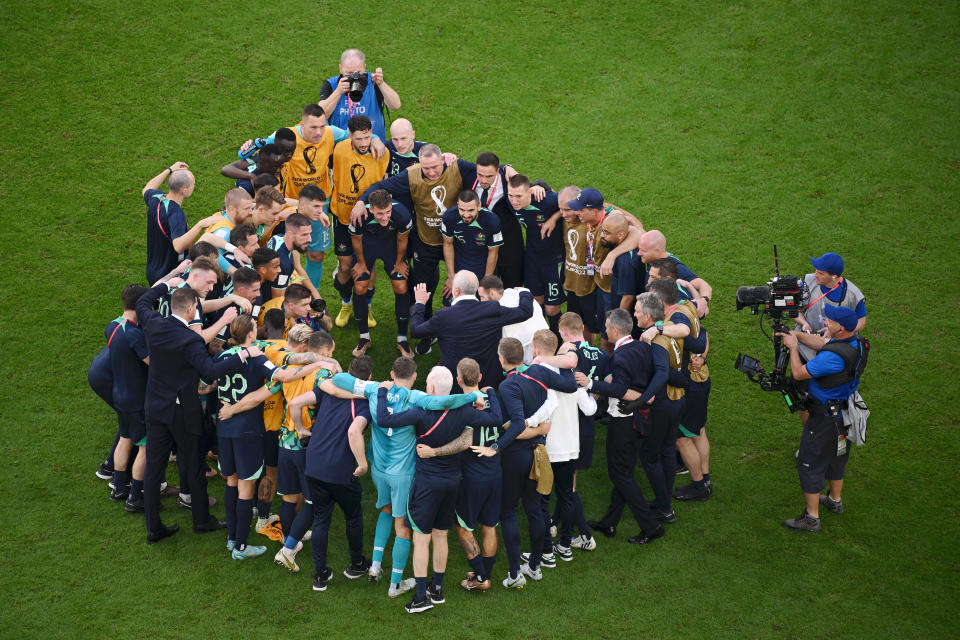 Graham Arnold, pictured here celebrating with his players after the Socceroos' win over Tunisia at the World Cup.