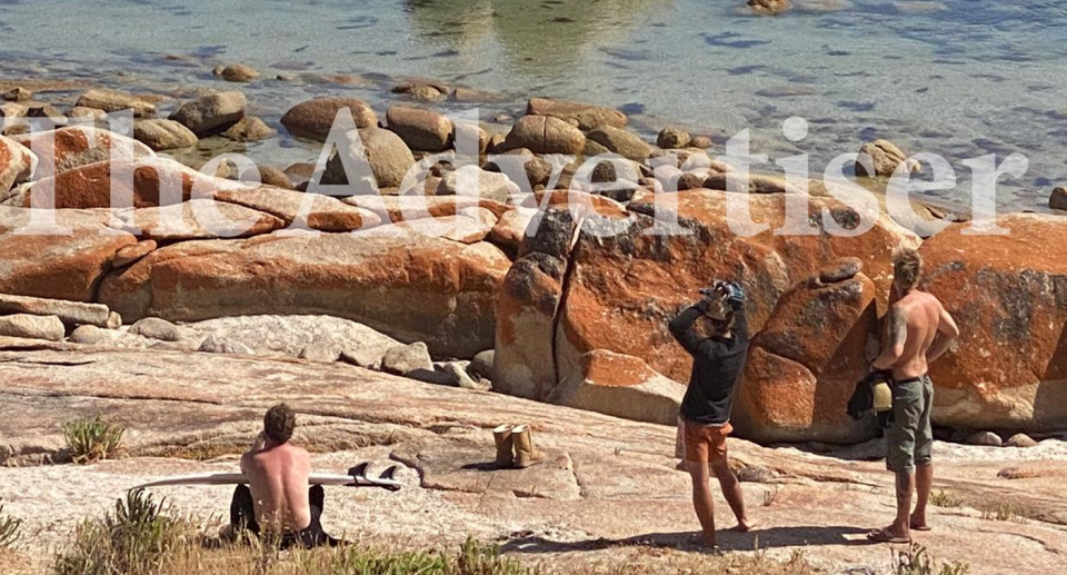 People at Granite Rock waiting helplessly for any sign of the injured surfer who was mauled by a shark. An empty pair of Ugg boots remain on the rocks.Source: The Adelaide Advertiser. 