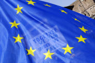 A placard in support of the European Union is seen through an European flag as demonstrators prepare to take part into a demonstration in support of the European Union in Rome, Saturday, March 25, 2017, the day leaders of the European Union gathered in Rome to mark the 60th anniversary of the bloc. (AP Photo/Gregorio Borgia)