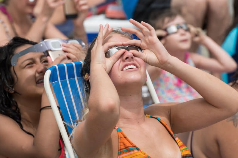 Beachgoers watch the total solar eclipse on the beach in Isle of Palms, S.C., in August 2017, taking precautions to prevent eye damage. File Photo by Richard Ellis/UPI