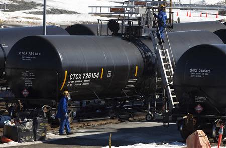 Irving Oil workers inspect rail cars carrying crude oil at the Irving Oil rail yard terminal in Saint John, New Brunswick, March 9, 2014. REUTERS/Devaan Ingraham