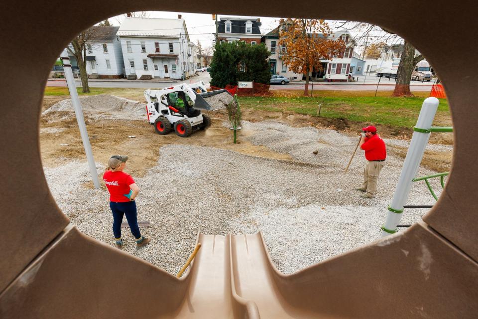 Volunteers and public works crews install a new playground at Wirt Park on Friday.