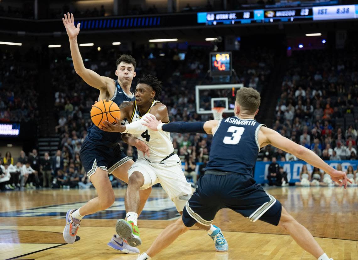 Missouri Tigers guard D’Moi Hodge (5) drives between Utah State Aggies guard Steven Ashworth (3) and Utah State Aggies forward Taylor Funk (23) during a game for the NCAA Tournament at Golden 1 Center in Sacramento, Thursday, March 16, 2023.