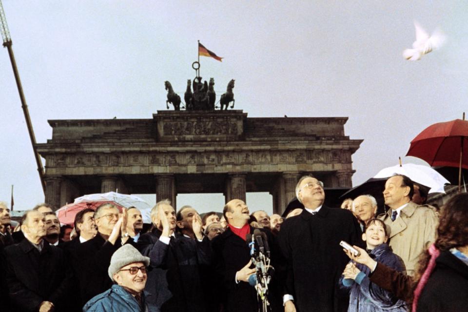 West German chancellor Helmut Kohl, East German prime minister Hans Modrow and West Berlin mayor Walter Momper wave to the crowd, 1989 (DPA/AFP/Getty)