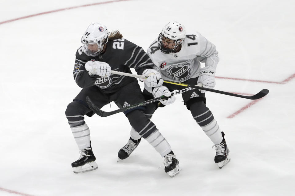 FILE - United States' Kacey Bellamy (22) and Canada's Renata Fast (14) battle for the puck during the first period in the women's 3-on-3 game, part of the NHL hockey All-Star weekend, Friday, Jan. 24, 2020, in St. Louis. Sharing the ice during NHL All-Star festivities and informal training skates and crossing paths at various Olympics over the past several years, some of the best men's and women's hockey players in the world got to talking. (AP Photo/Jeff Roberson, File)