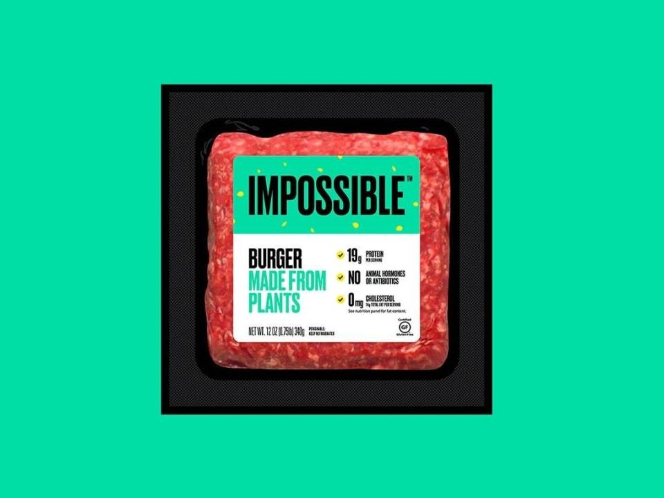 A package of impossible meat over a turquoise background