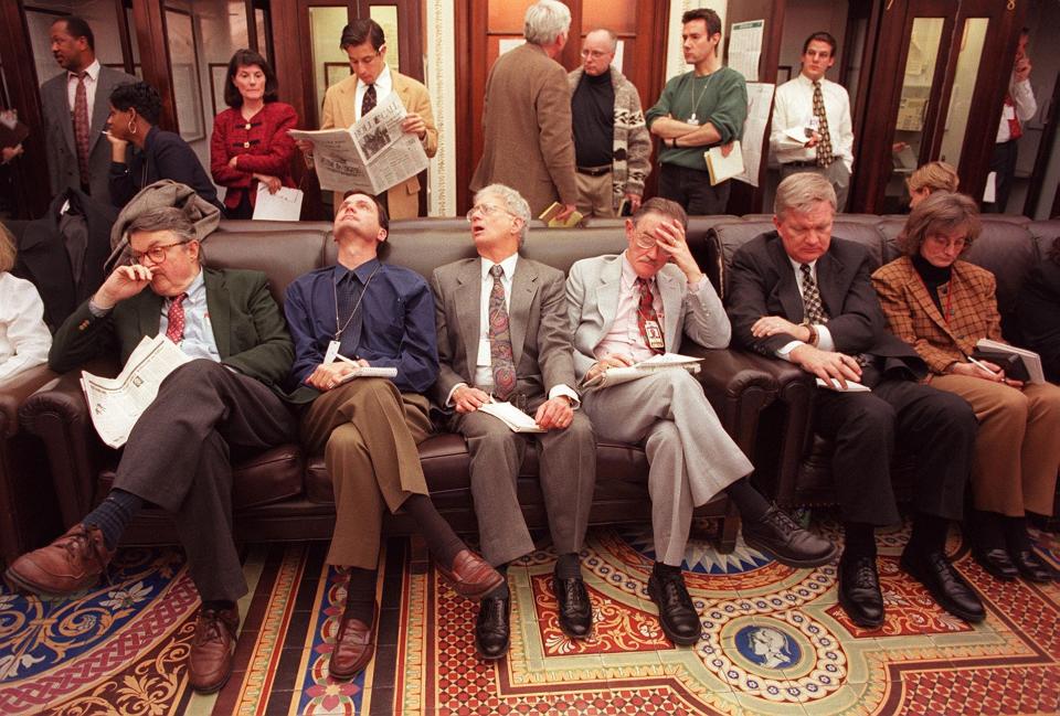 Unidentified members of the press wait outside the Senate chamber as the impeachment trial of US President Bill Clinton begins 07 January on Capitol Hill in Washington, DC. Clinton's impeachment trial opened 07 January -- the first such proceeding in 131 years -- as senators weighed his ouster over lying about sex in the White House. (