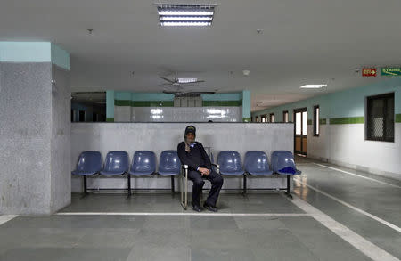 A private security guard sits at Janakpuri Super Speciality Hospital in New Delhi January 19, 2015. REUTERS/Adnan Abidi/Files