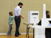 Liberal leader Justin Trudeau votes with the help of son Hadrien in Montreal, Quebec on Monday, Sept. 20, 2021. Canadians are voting in a pandemic election that threatens to knock Prime Minister Justin Trudeau from power. Trudeau gambled on an early election Monday in a bid to win a majority of seats in Parliament. (Sean Kilpatrick/The Canadian Press via AP)