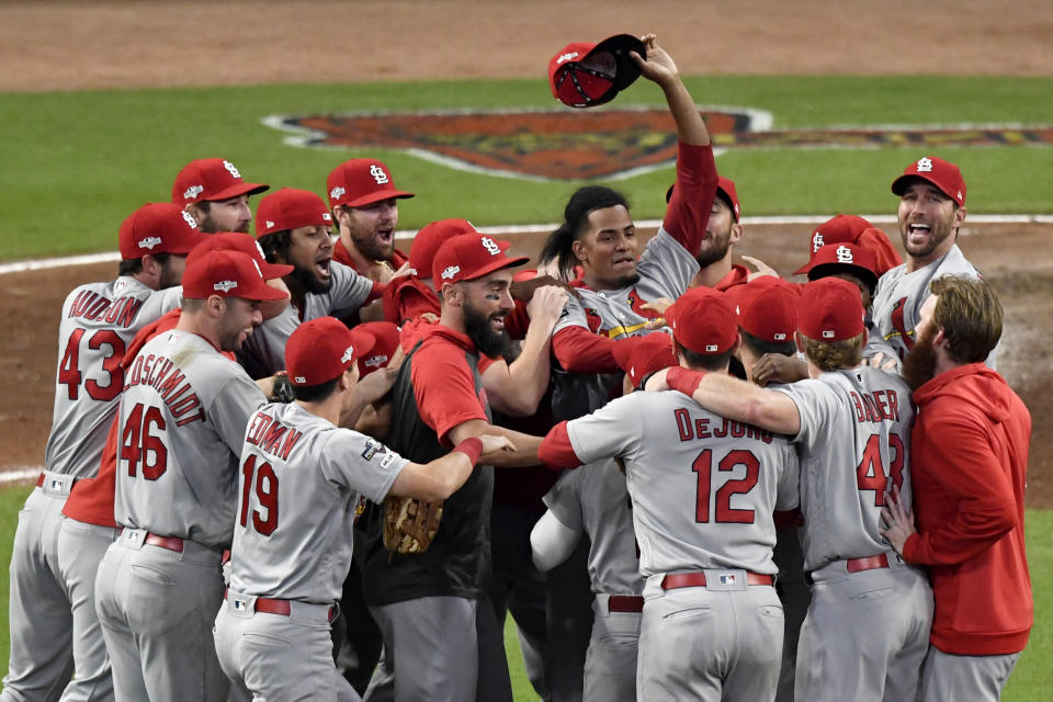 St. Louis Cardinals relief pitcher Genesis Cabrera waves his hat in the air as he celebrates with teammates after the Cardinals beat the Atlanta Braves 13-1 in Game 5 of their National League Division Series baseball game Wednesday, Oct. 9, 2019, in Atlanta. (AP Photo/Danny Karnik)