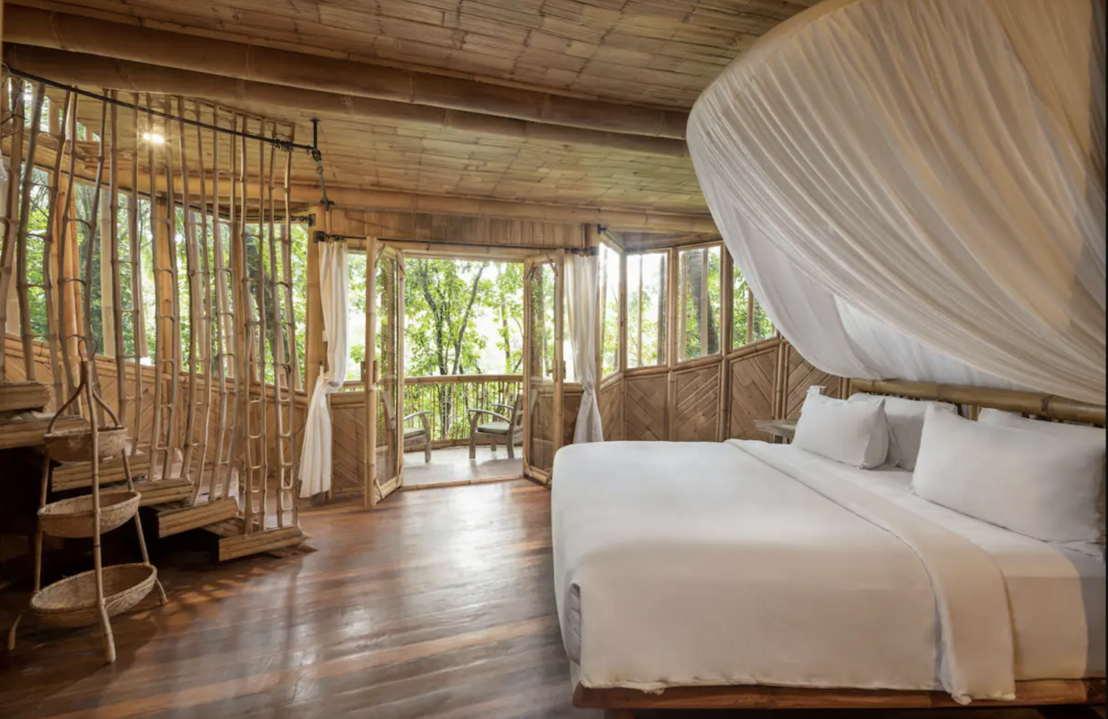 One-Bedroom Bamboo Villa with Riverfront View: bedroom with white canopy bed