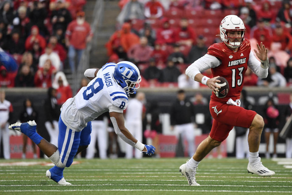 Louisville quarterback Jack Plummer (13) runs from the defense of Duke linebacker Dorian Mausi (8) during the second half of an NCAA college football game in Louisville, Ky., Saturday, Oct. 28, 2023. (AP Photo/Timothy D. Easley)