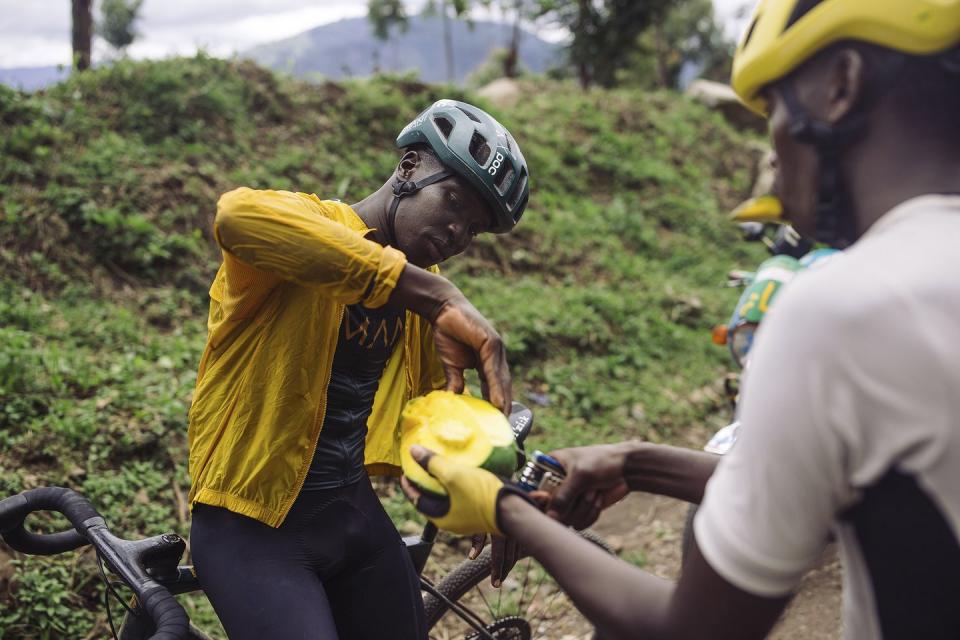 cyclists on team amani snack on a mango during a training ride in iten kenya