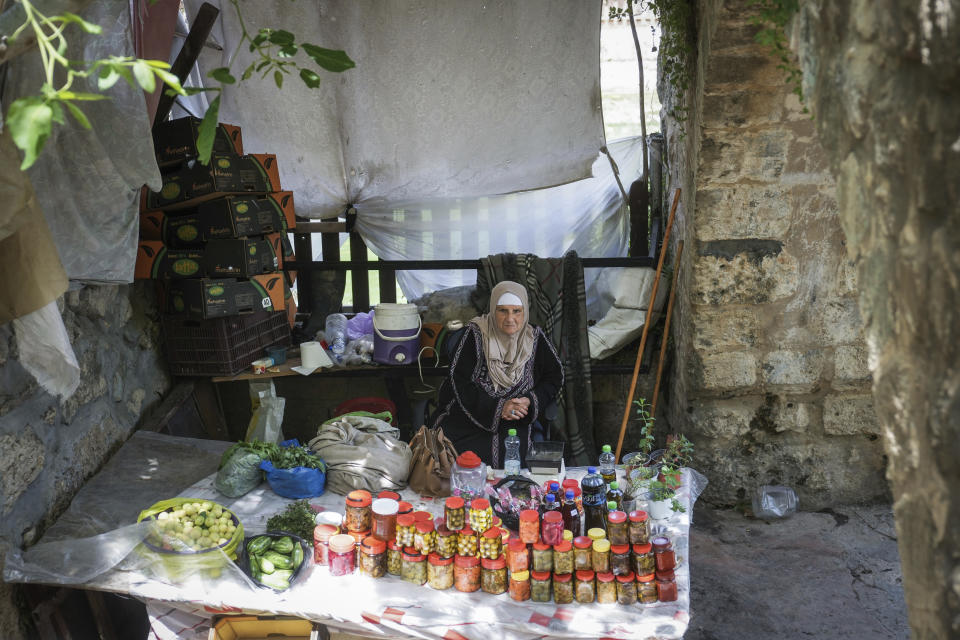 A Palestinian vendor sells produce made by farmers in the West Bank village of Battir Sunday, June 4, 2023. Environmental groups say an Israeli settlement project slated for a nearby hilltop could threaten the ancient terraces of the village, which has been recognized as a UNESCO world heritage site. (AP Photo/Mahmoud Illean)