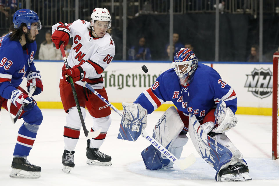 New York Rangers center Mika Zibanejad, left, and goaltender Henrik Lundqvist (30) watch with Carolina Hurricanes left wing Erik Haula (56) as the puck bounces in front of Lundqvist during the first period of an NHL hockey game Friday, Dec. 27, 2019, in New York. (AP Photo/Kathy Willens)
