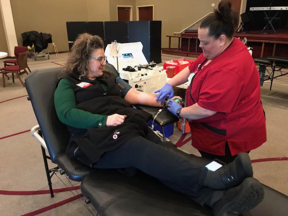 Laura Kreger of Monroe (left) donates a double unit of red blood cells at an American Red Cross blood drive Thursday at Monroe Church of the Nazarene. Assisting her is Sandy Castro, a phlebotomist for the Red Cross who managed an apheresis machine (behind Kreger) used to process the blood donation intended for people needing transfusions.