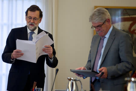 Spain's Prime Minister Mariano Rajoy (L) reads documents next to Foreign Minister Alfonso Dastis before presiding over an extraordinary cabinet meeting at Moncloa Palace in Madrid, Spain October 27, 2017. REUTERS/Moncloa/Diego Crespo/Handout via REUTERS 
