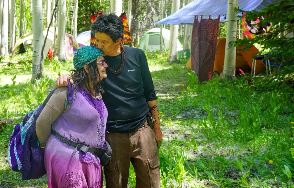 Asistentes a la reunión de la Familia Arcoíris abrazándose durante los preparativos para el campamento anual, que este año se realizará en una zona remota del Bosque Nacional Routt en Colorado, el 26 de junio.