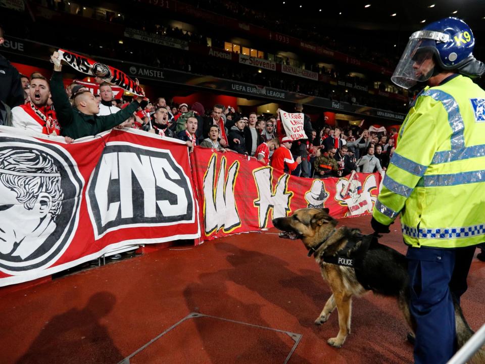 Police dogs guard fans at the away end at Emirates Stadium: Getty Images