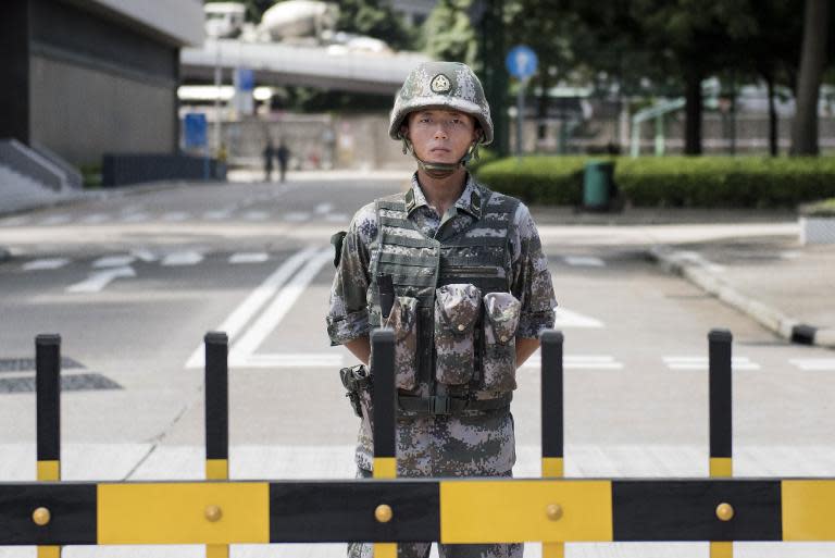 A Chinese People's Liberation Army (PLA) soldier stands guard at the entrance to the PLA's Hong Kong Garrison headquarters in Hong Kong on August 29, 2014