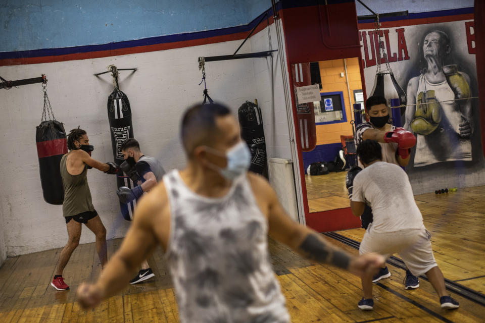 Men wearing face masks to prevent the spread of the coronavirus, exercise at a boxing gym in the southern neighbourhood of Vallecas in Madrid, Spain, Monday, Sept. 28, 2020. (AP Photo/Bernat Armangue)