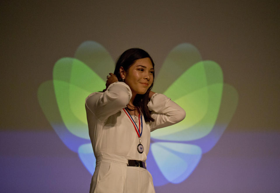In this Dec.18, 2018 photo, Angela, a transgender girl, is given a "Best Effort" medal during the Amaranta Gomez school graduation ceremony, in Santiago, Chile. Despite the lack of resources, the foundation has started a summer school that offers dance and other workshops for about 20 children, including some who are not attending the school. (AP Photo/Esteban Felix)