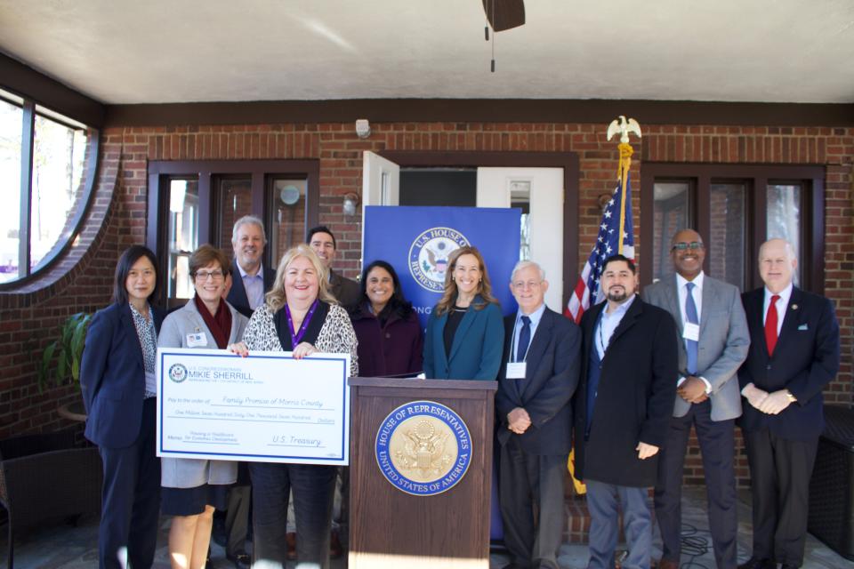 Family Promise of Morris County CEO  Joann Bjornson holds a ceremonial check for $1.7 million, representing federal community project funding presented by Rep. Mikie Sherrill (D-Montclair, center) at the nonprofit's headquarters in Morris Plains.