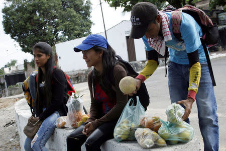 Marlon Carrillo (R) organizes the fruits bought in Venezuela as he waits for customers in Cucuta, Colombia December 15, 2017. REUTERS/Carlos Eduardo Ramirez