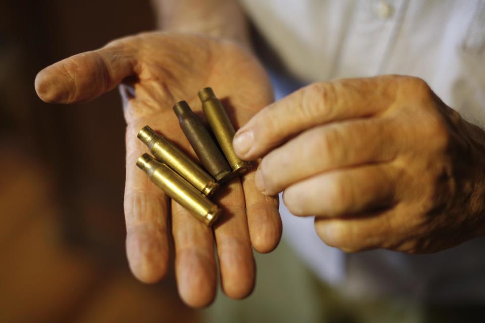 Juan Carlos Pallarols, 74, holds spent bullet casings from the Falklands war, at his studio in Buenos Aires, Argentina, Wednesday, Jan. 25, 2017. Pallarols, an Argentine goldsmith known for crafting the presidential batons, collects old ammunition from the 1982 Falklands war to craft roses which he will send to the Argentine and British war cemeteries in the islands in an effort to build a bridge of peace and understanding between the nations. (AP Photo/Victor R. Caivano)