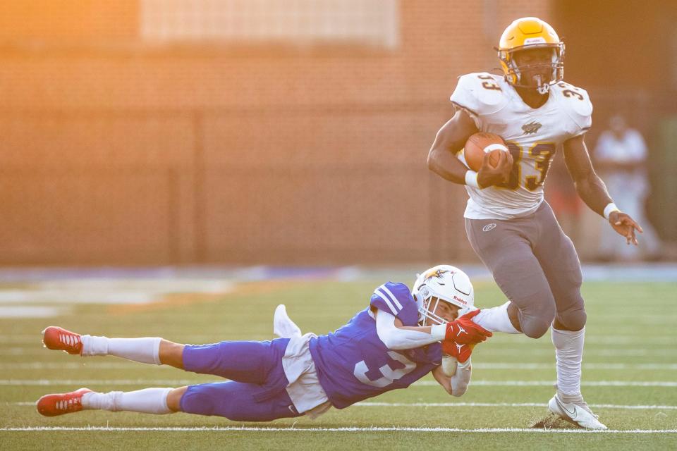 Adams’ Quincy To'oto'o (3) grabs Riley's Robert Nabieu (33) by the foot during the Adams vs. Riley High School football game Friday, Sept. 1, 2023 at School Field in South Bend.