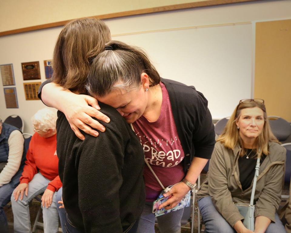 A teacher of 18 years, Rachel McCarthy, right, gets a hug after speaking emotionally during the RSU 21 School Board meeting May 10, 2024.