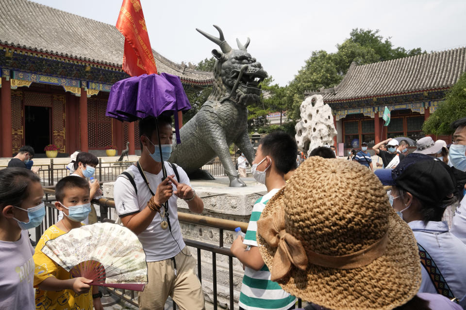 A tour guide leads a group of domestic tourists visiting the Summer Palace in Beijing on Aug. 3, 2021. Strict virus control measures have allowed China to return to relatively normal life. The number of tourists visiting Beijing in June and July tripled compared to the same period last year, while revenue quadrupled, according to Trip.com, China's largest online travel booking platform. (AP Photo/Ng Han Guan)