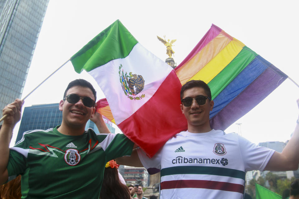 Hinchas mexicanos posan con una bandera del Orgullo Gay y una bandera de México, en cercanías del Ángel de la Independencia, en Ciudad de México. Foto: Elizabeth Ruiz para Yahoo Deportes