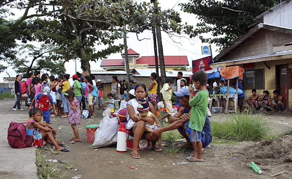 Residents wait to be transferred to an evacuation center in Tacloban city, central Philippines December 4, 2014. Schools and government offices were shut in parts of the central Philippines on Thursday and residents stocked up on supplies and food, as provinces yet to recover from last year's devastating super-typhoon Haiyan braced for another category 5 storm. Typhoon Hagupit was churning across the Pacific around 860 km (585 miles) east of the island nation on Thursday, the local weather bureau said, packing winds of up to 195 kph (120 mph) with gusts of up to 230 kph. REUTERS/Stringer (PHILIPPINES - Tags: POLITICS DISASTER)