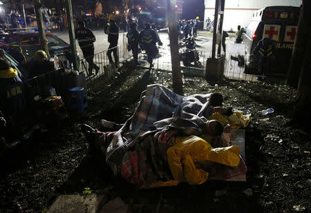 Relatives sleep as they waiting for news of their loved ones next to a collapsed building after an earthquake in Mexico City, Mexico September 22, 2017. REUTERS/Henry Romero