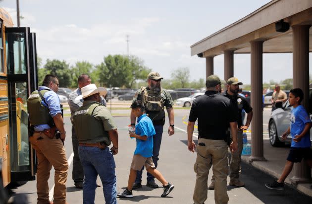 Children get on a school bus as law enforcement personnel guard the scene of a shooting near Robb Elementary School in Uvalde, Texas, on Tuesday. (Photo: MARCO BELLO / REUTERS)