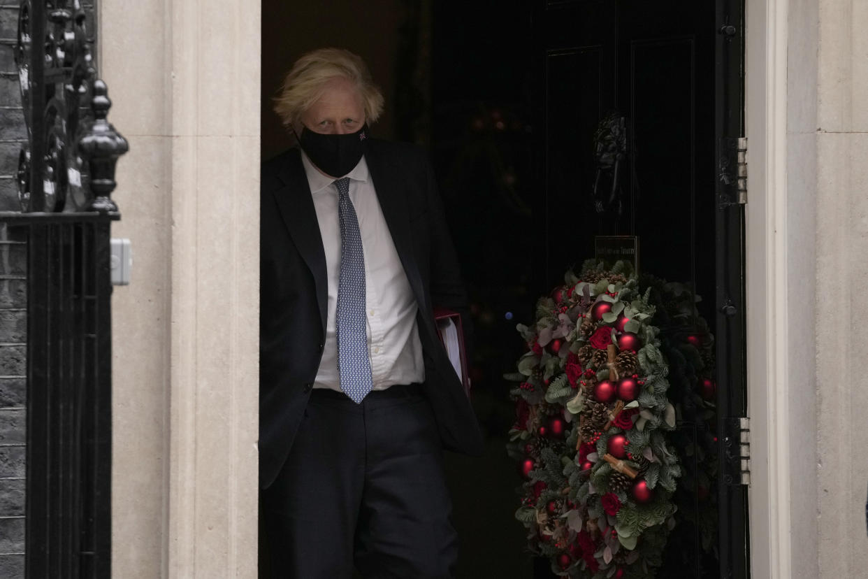 British Prime Minister Boris Johnson leaves 10 Downing Street to attend the weekly Prime Minister's Questions at the Houses of Parliament, in London, Wednesday, Dec. 8, 2021. (AP Photo/Matt Dunham)