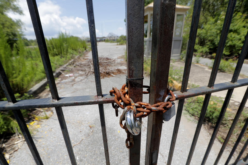 This June 19, 2019, photo shows the gates of the abandoned Six Flags Great Adventure Amusement Park in New Orleans. The abandoned New Orleans amusement park that has stood empty since Hurricane Katrina in 2005 may finally be torn down. The Six Flags park never reopened after the levees failed and flooded the city with water. Mayor LaToya Cantrell says her office is targeting the site for demolition. (AP Photo/Gerald Herbert)