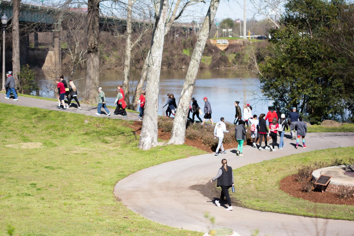 People walk along the Tuscaloosa Riverwalk in this  March 7, 2020, photo. On Saturday, the Phoenix House will host the "Walk to End Addiction" at the Riverwalk.  (Photo / Keely Brewer)