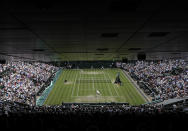 Serbia's Novak Djokovic, bottom, serves to Belgium's David Goffin during a men's quarterfinal match on day nine of the Wimbledon Tennis Championships in London, Wednesday, July 10, 2019. (AP Photo/Kirsty Wigglesworth)