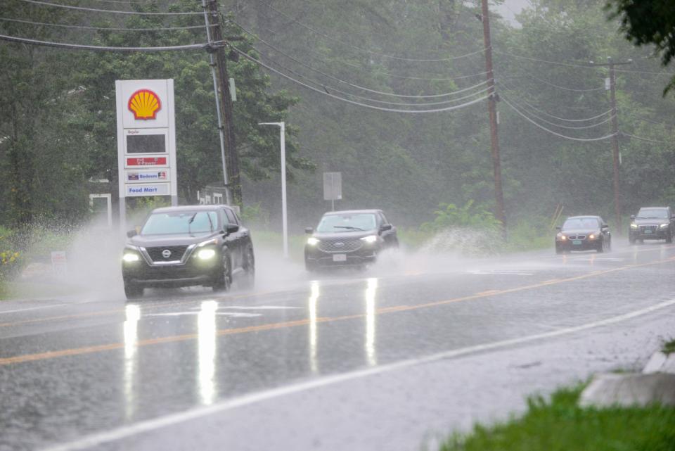 Vehicles drive through the water flowing over Route 9 in Brattleboro, Vt., on Monday, July 10, 2023. (Kristopher Radder/The Brattleboro Reformer via AP)