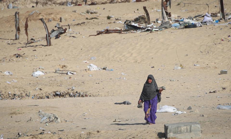 <span>A displaced Palestinian woman leaves a dismantled camp in Rafah as people moved to safer areas in central Gaza on 15 May while Israeli forces continue to attack Hamas militants around the southern Gaza Strip city.</span><span>Photograph: AFP/Getty Images</span>