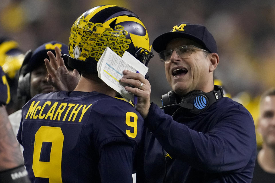 Michigan head coach Jim Harbaugh takes with quarterback J.J. McCarthy during the first half of the national championship NCAA College Football Playoff game against Washington Monday, Jan. 8, 2024, in Houston. (AP Photo/David J. Phillip)