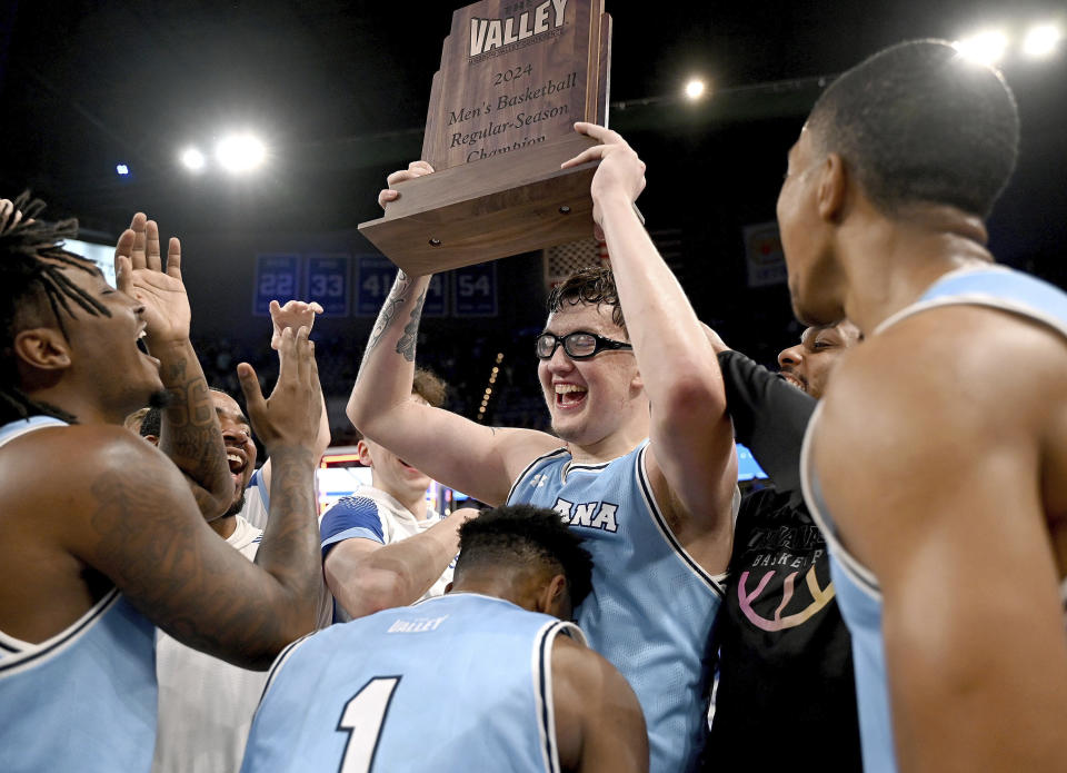 Indiana State's Robbie Avila raises the Missouri Valley Conference men's basketball regular-season championship trophy as he celebrates with teammates after an NCAA college basketball game against Murray State, Sunday, March 3, 2024, in Terre Haute, Ind. (Joseph C. Garza/The Tribune-Star via AP)